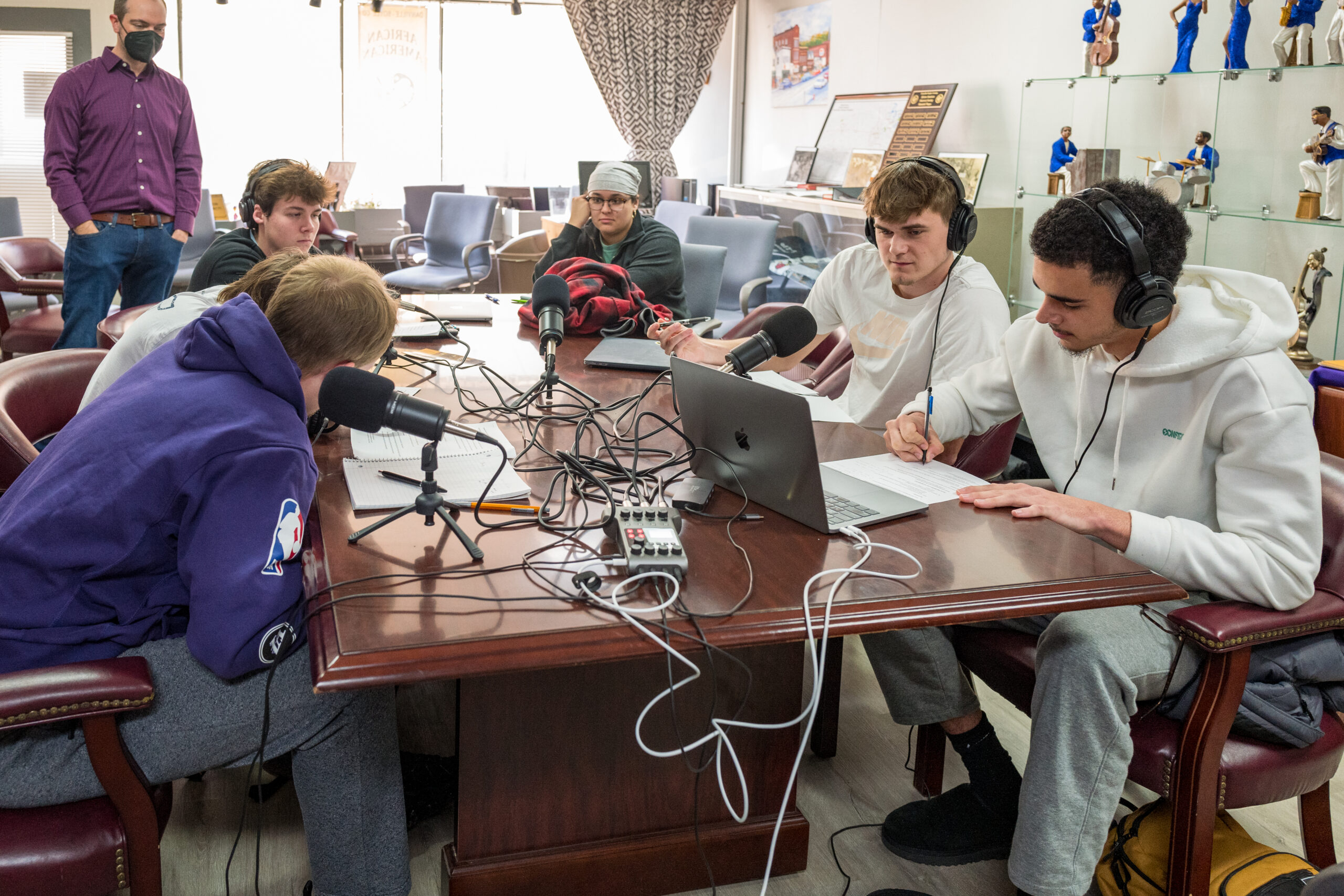 Centre students sit around a table with sound recording equipment