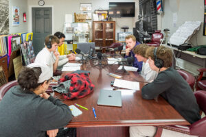 Centre students sit around a table with sound recording equiptment.