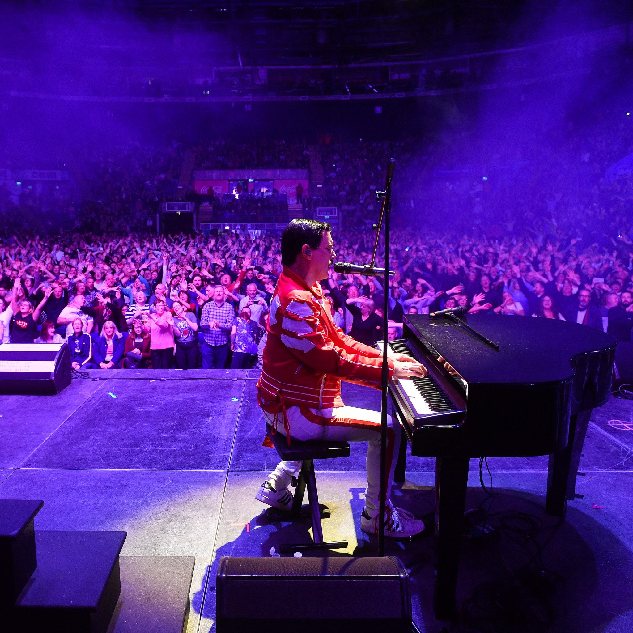 Patrick Meyers as Freddie Mercury playing piano to a crowd