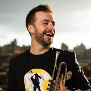Man smiling holding a trumpet