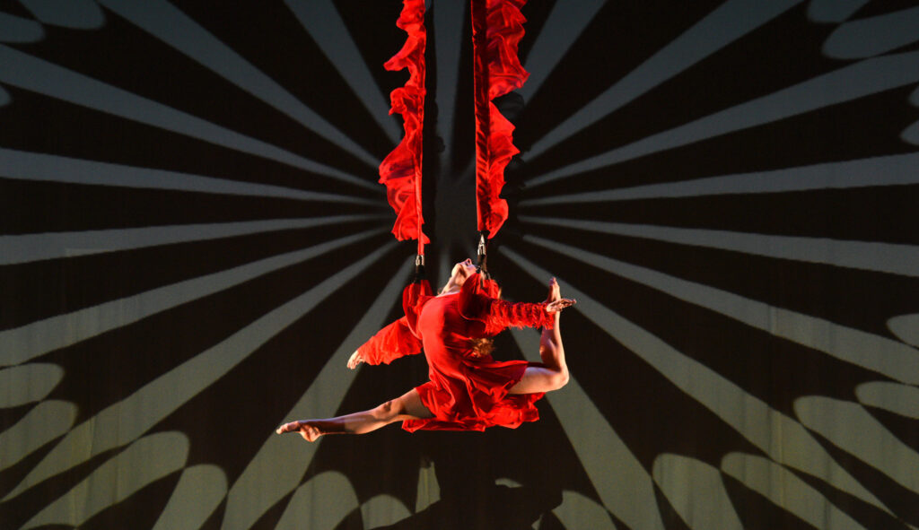 Woman dressed in red hung in the air with red straps