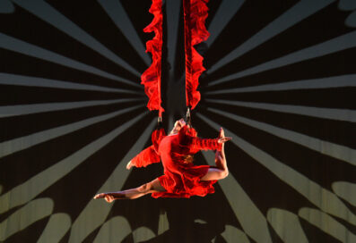 Woman Dressed In Red Hung In The Air With Red Straps