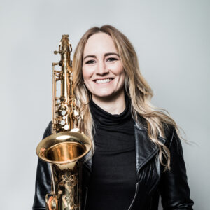 Woman poses for a portrait holding a saxophone