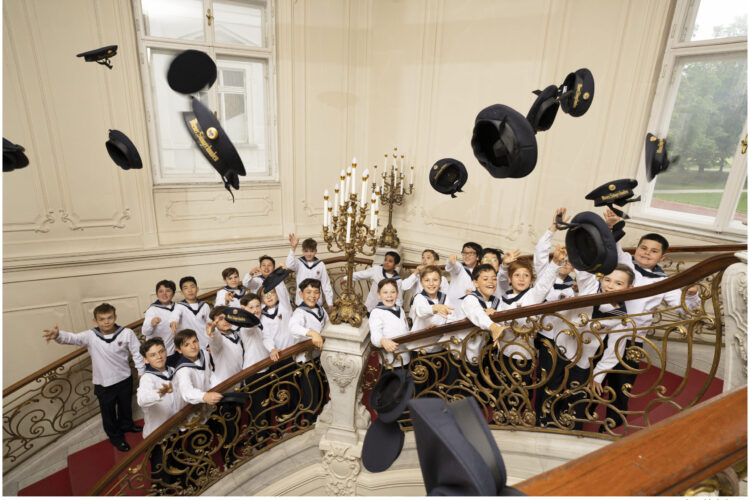 Choir Boys Standing On A Staircase Together, Throwing Their Hats Into The Air.