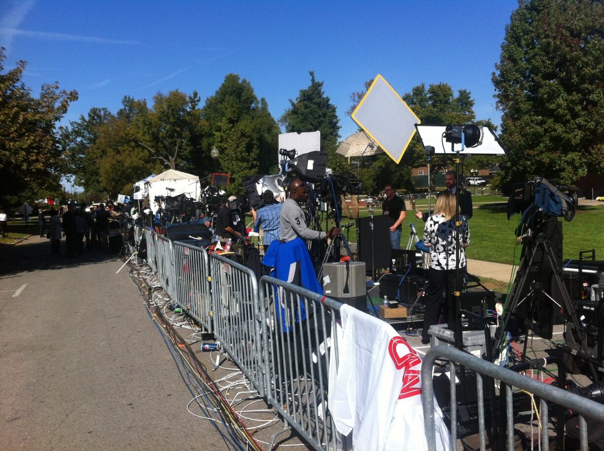 Media crews lining the street with a gate keeping them separated