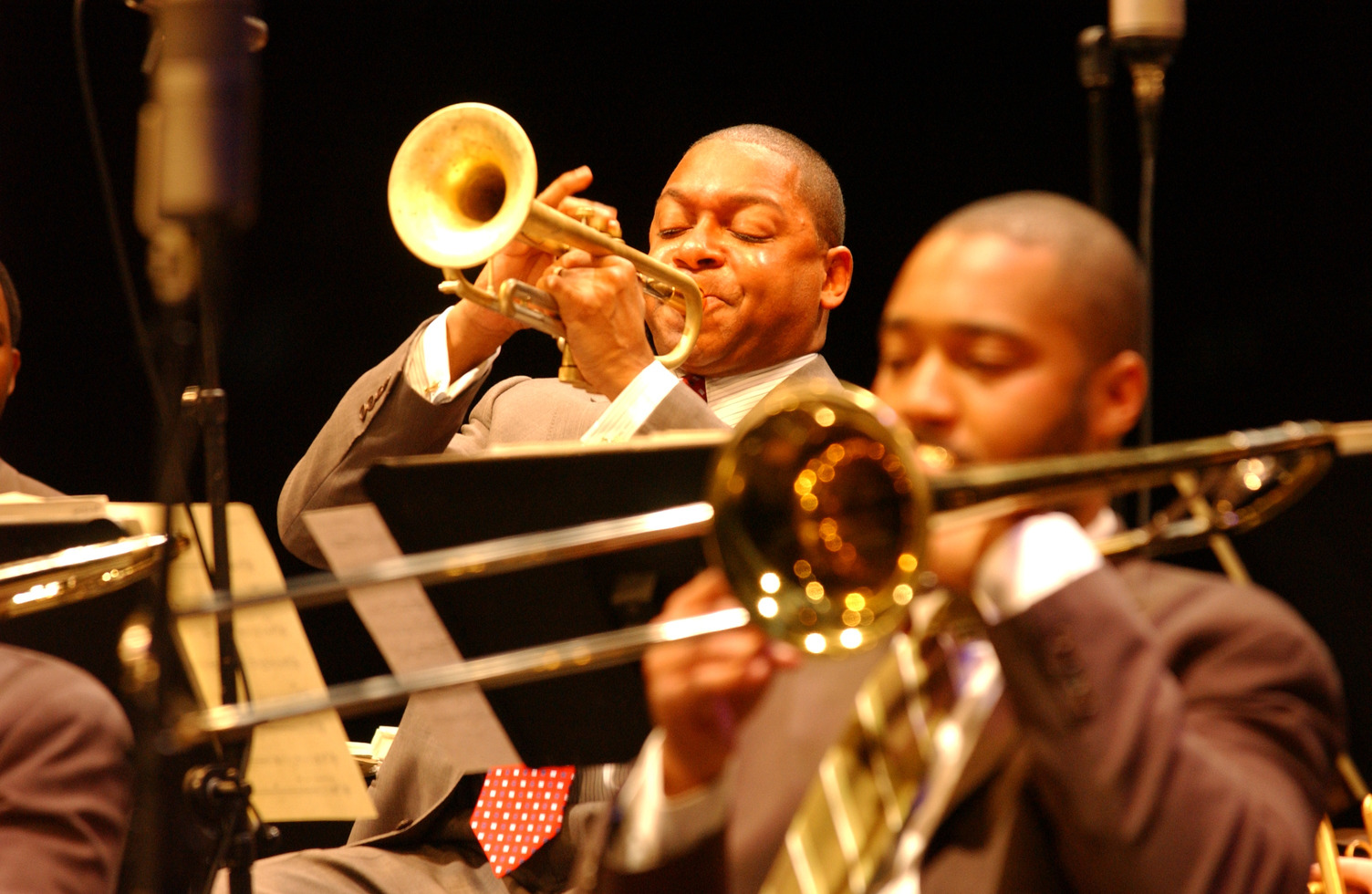 Wynton Marsalis playing trumpet, with another musician playing trombone in the foreground.