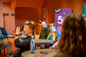 Michael Cleveland speaks to people during a roundtable forum. A sign language interpreter signs in the foreground