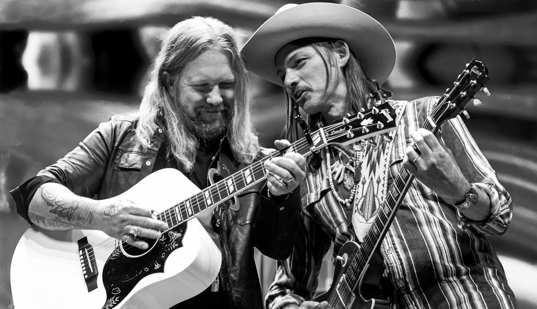 Black and white photograph of Allman Betts playing guitars next to one another