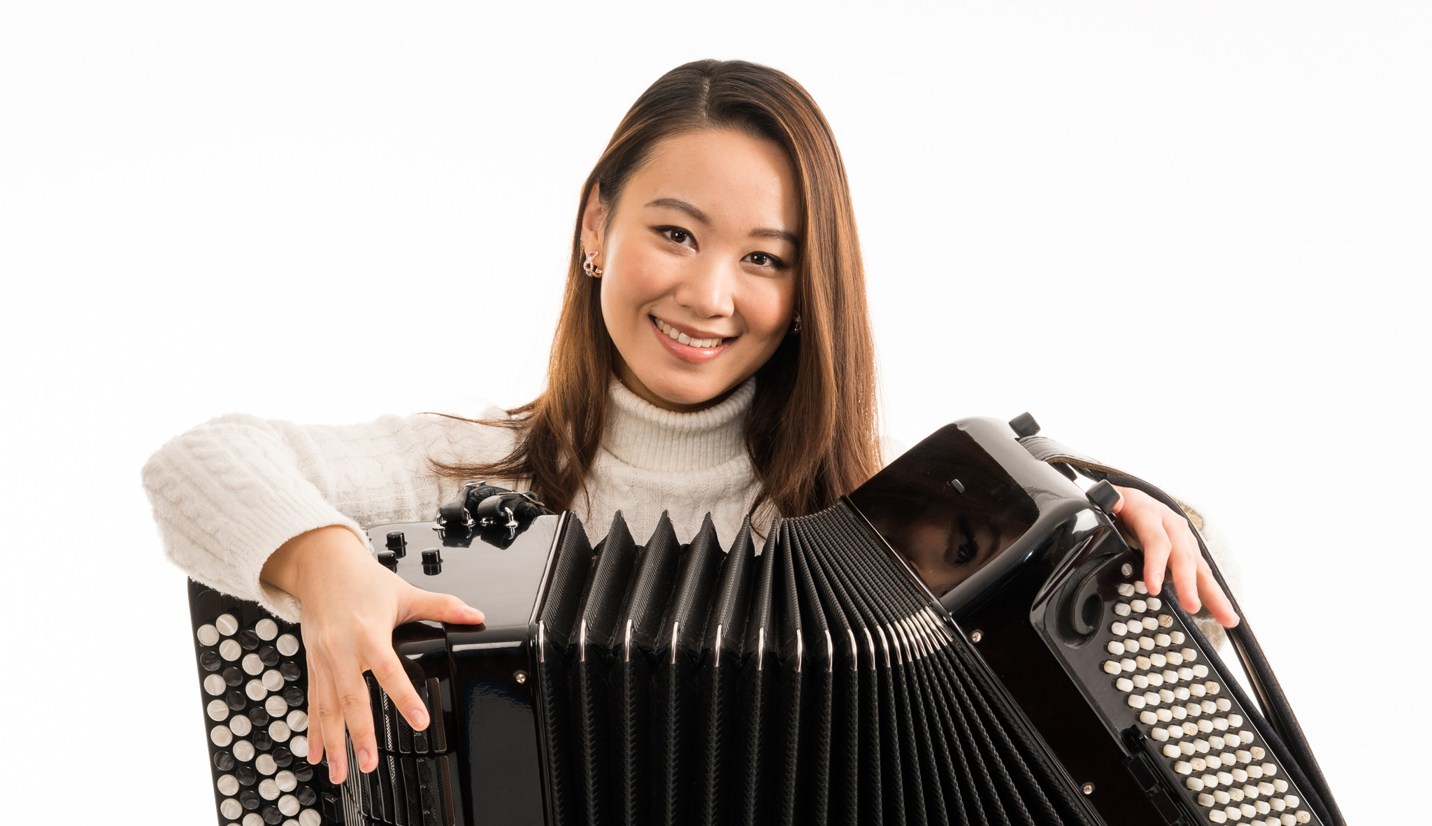 Hanzhi Wang holding her accordion and smiling at the camera
