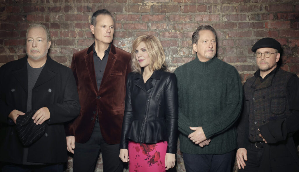 Alison Krauss and Union Station members posing against a brick wall