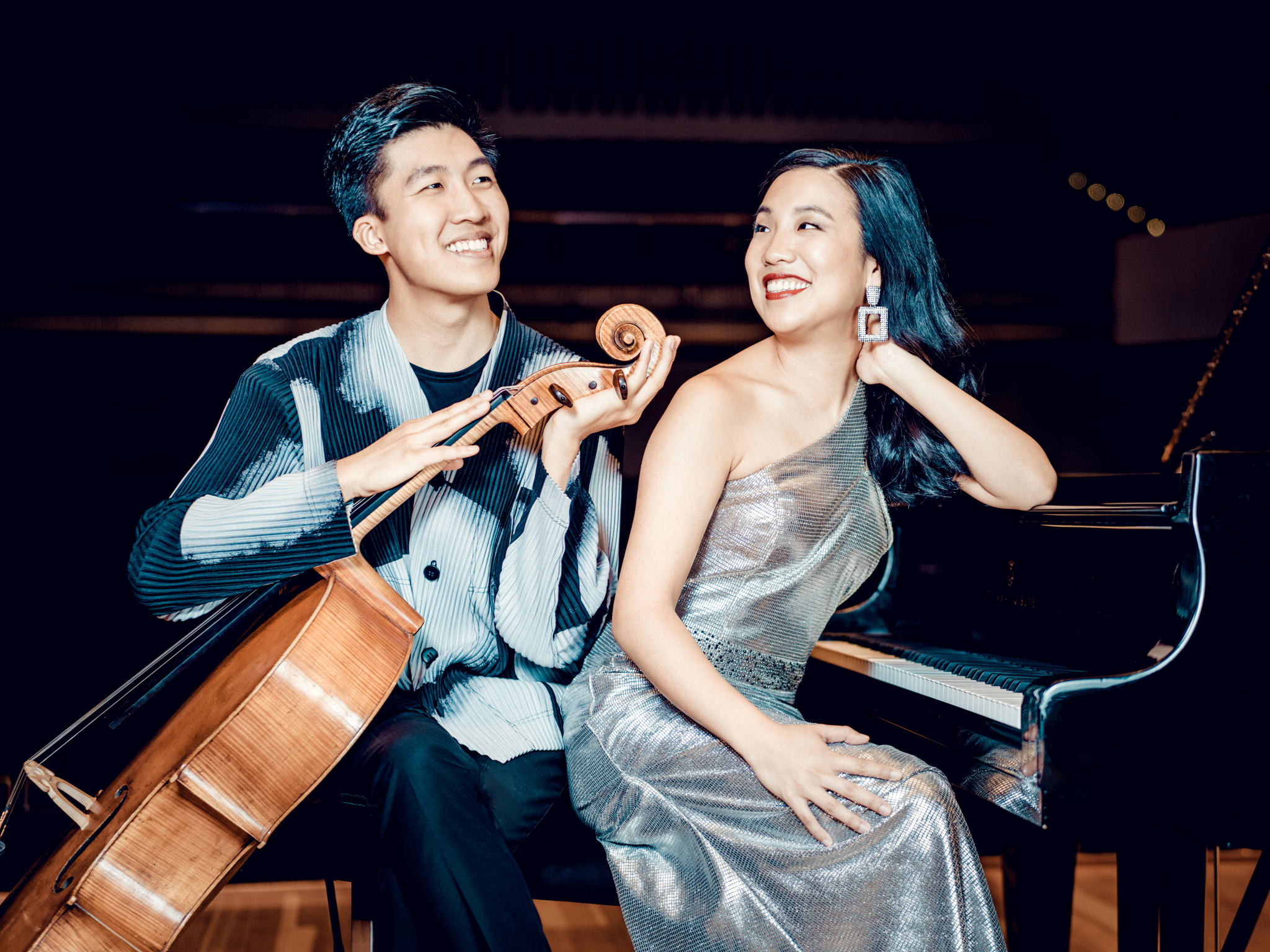 Brother and sister of Cheng Squared Duo pose with their instruments, a cello and piano