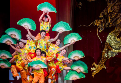 The Peking Acrobats Stacked On One Another's Shoulders, Holding Colorful And Fans