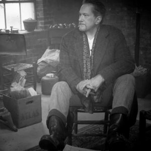 Black and white portrait of Jerry Douglas sitting in a chair with his feet propped up