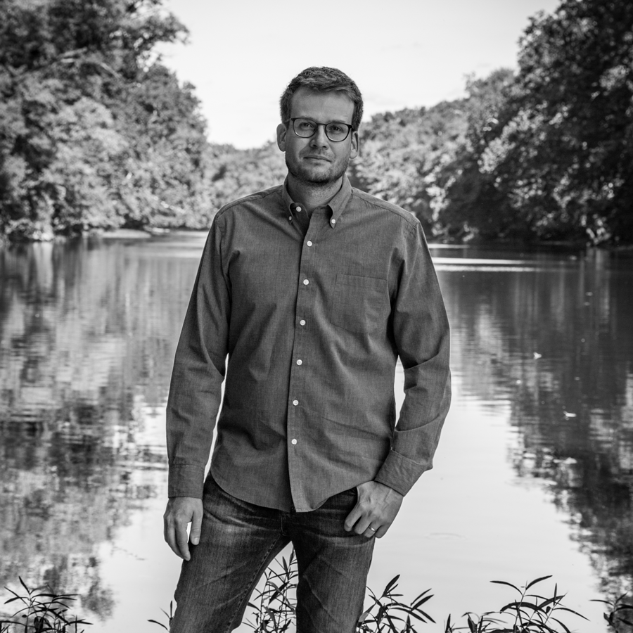 Author John Green standing in front of a pond.